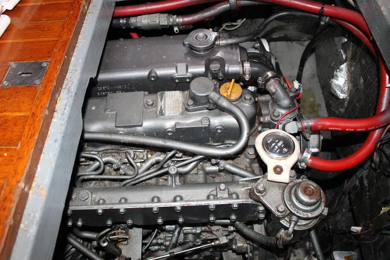 Slide: The Image of Engine compartment of a 1990 Slocum 43 sailboat, featuring red hoses and mechanical components. - 24