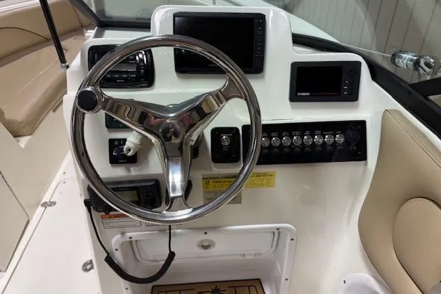 Slide: The Image of 2020 NauticStar 2302 Legacy Dual Console boat dashboard with steering wheel and controls. - 10