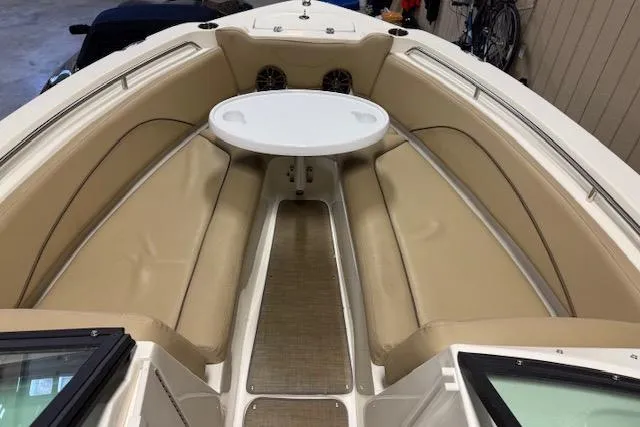 Slide: The Image of 2020 NauticStar 2302 Legacy Dual Console boat interior with beige seating and round table. - 19