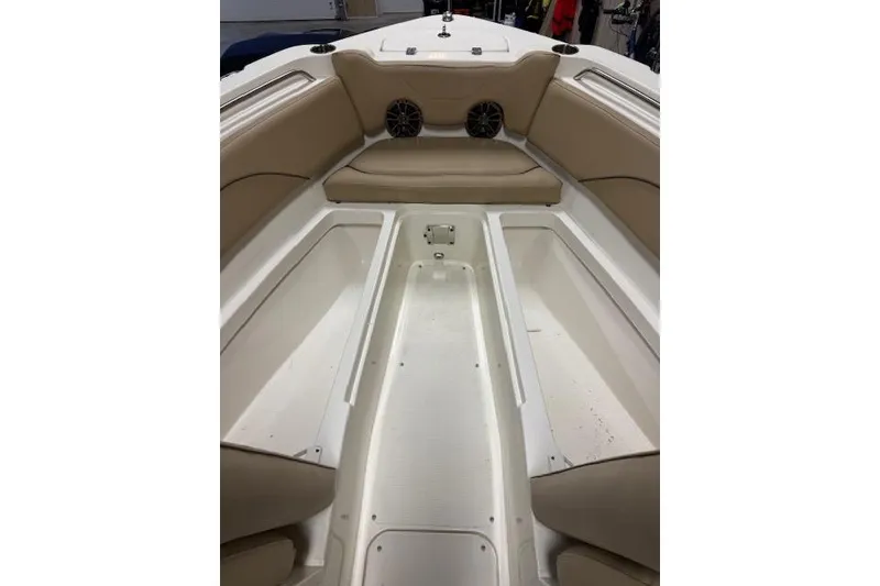 Slide: The Image of 2020 NauticStar 2302 Legacy Dual Console boat interior with beige seating and storage compartments. - 20