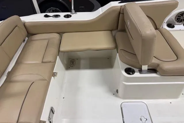 Slide: The Image of 2020 NauticStar 2302 Legacy Dual Console boat interior with beige seating and cup holders. - 24