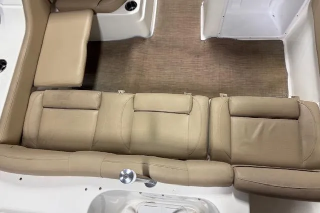 Slide: The Image of 2020 NauticStar 2302 Legacy Dual Console interior with beige seating and carpeted floor. - 26