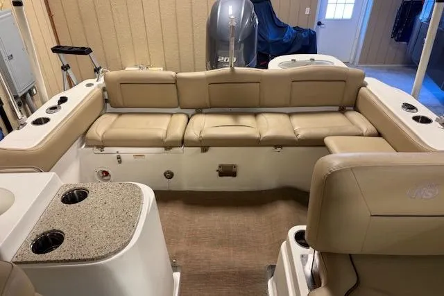 Slide: The Image of 2020 NauticStar 2302 Legacy Dual Console interior with beige seating and cup holders. - 27