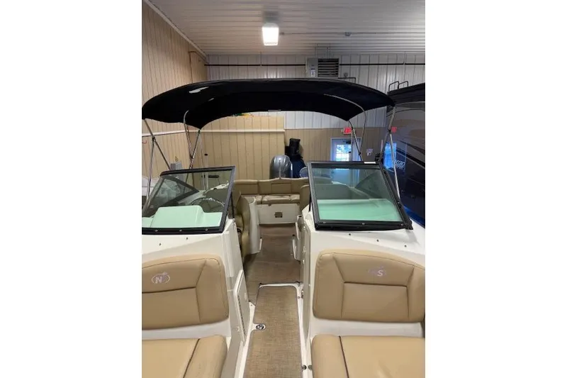 Slide: The Image of 2020 NauticStar 2302 Legacy Dual Console boat with tan seating and black canopy. - 28