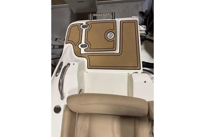Slide: The Image of 2020 NauticStar 2302 Legacy Dual Console boat interior with tan seating and deck. - 29