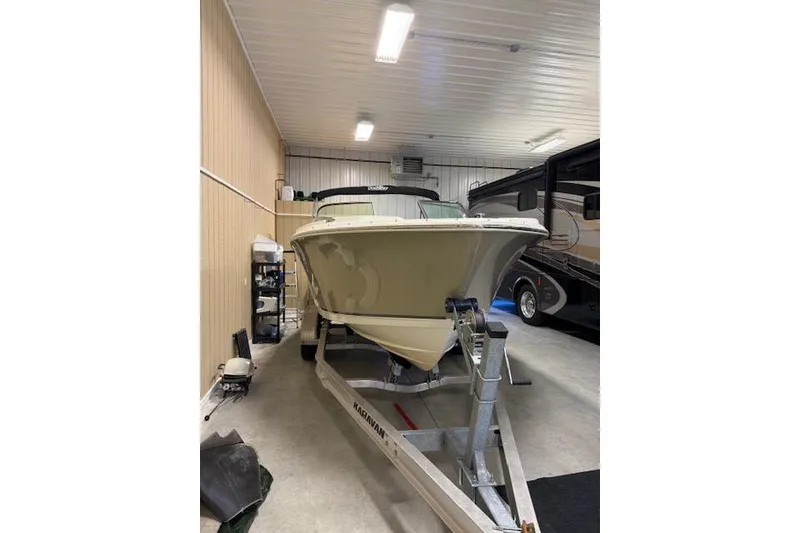 Slide: The Image of 2020 NauticStar 2302 Legacy Dual Console boat in indoor storage on trailer. - 3