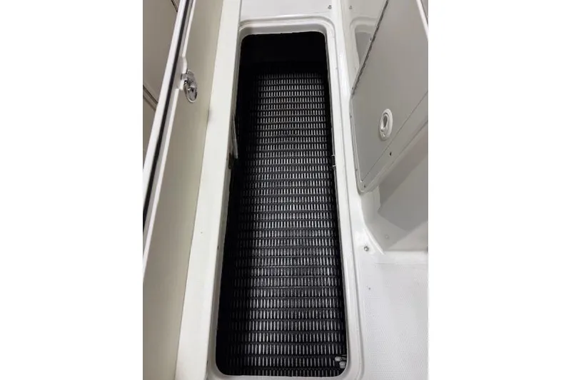 Slide: The Image of 2020 NauticStar 2302 Legacy Dual Console storage compartment with black mat. - 33