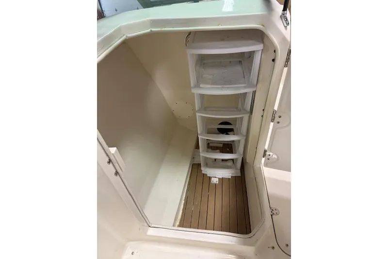 Slide: The Image of 2020 NauticStar 2302 Legacy Dual Console interior storage area with shelving. - 34