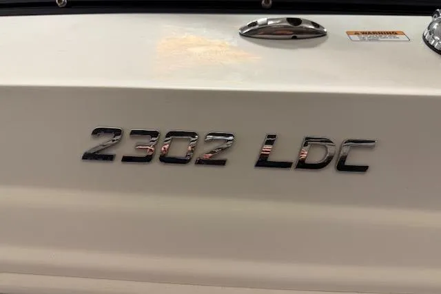 Slide: The Image of 2020 NauticStar 2302 Legacy Dual Console boat model emblem on white surface. - 5