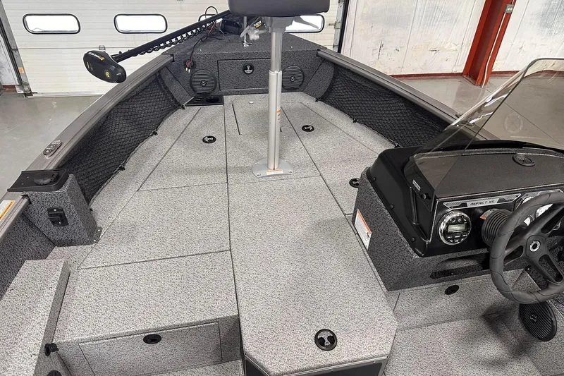 Slide: The Image of 2026 Lund 1775 Impact XS SS boat interior with steering console and seating area. - 11