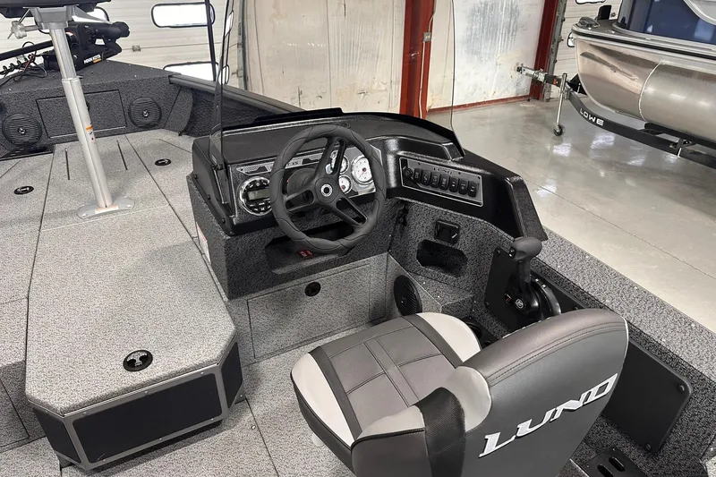 Slide: The Image of 2026 Lund 1775 Impact XS SS boat interior with steering wheel and control panel. - 15