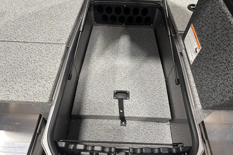 Slide: The Image of 2026 Lund 1775 Impact XS SS boat storage compartment with gray interior and rod holders. - 21