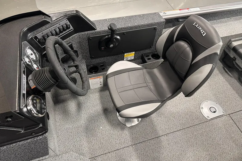Slide: The Image of 2026 Lund 1775 Impact XS SS boat interior with steering wheel and cushioned seat. - 25