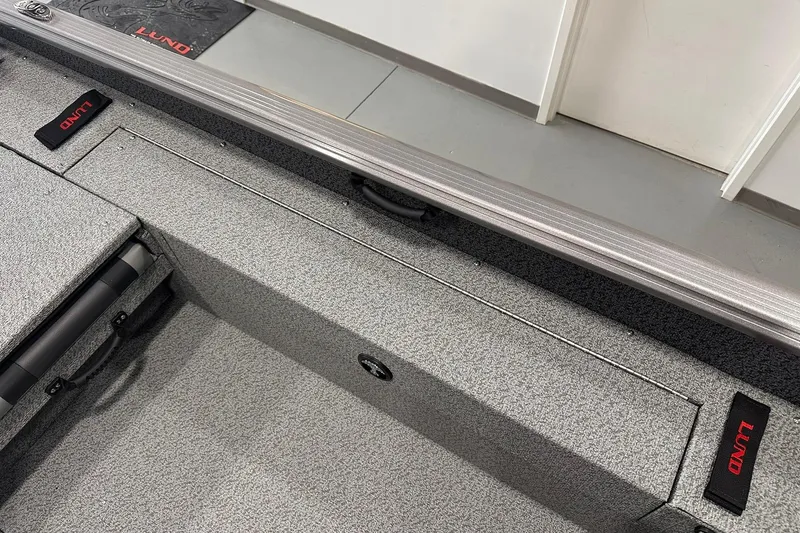 Slide: The Image of 2026 Lund 1775 Impact XS SS boat interior with gray textured flooring and storage compartments. - 28