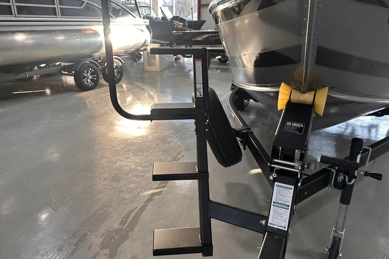 Slide: The Image of 2026 Lund 1775 Impact XS SS boat on trailer with step ladder in showroom. - 35