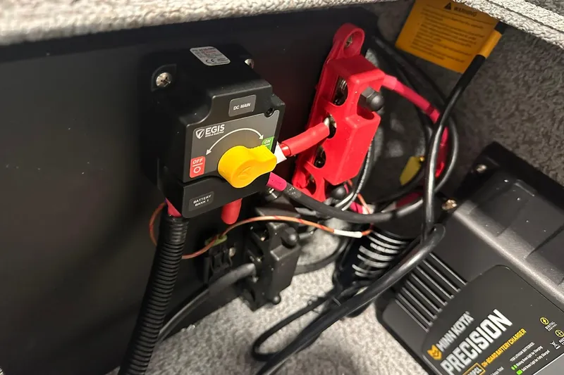 Slide: The Image of Electrical components in a 2026 Lund 1775 Impact XS SS boat, featuring a Minn Kota Precision charger. - 37