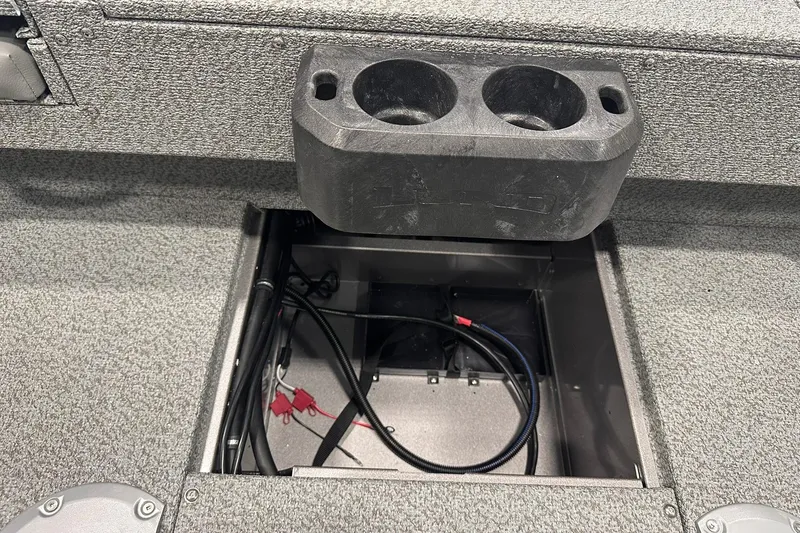 Slide: The Image of 2026 Lund 1775 Impact XS SS boat interior with open storage compartment and cup holders. - 38