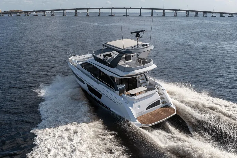 Slide: The Image of 2026 Azimut Fly 53 yacht cruising on open water near a bridge. - 5