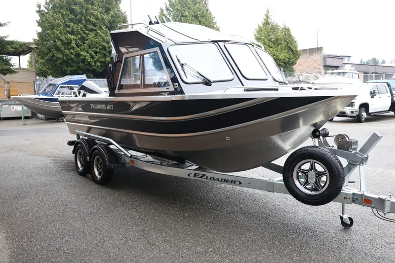 Slide: The Image of 2026 Thunder Jet 210 Luxor Limited boat on trailer, parked outdoors. - 4