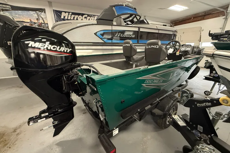 Slide: The Image of 2026 Lund Angler 1650 SS boat with Mercury engine in showroom display. - 11