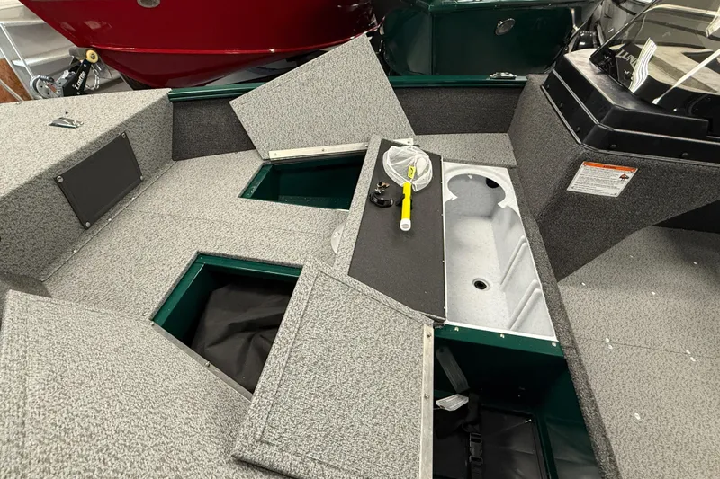 Slide: The Image of 2026 Lund Angler 1650 SS boat interior with storage compartments and fishing gear. - 12