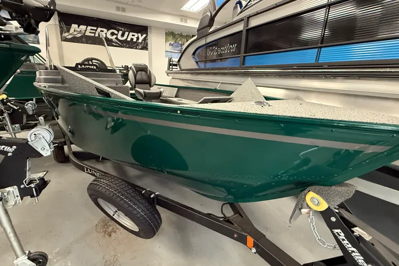 Slide: The Image of 2026 Lund Angler 1650 SS boat in showroom, green exterior, on trailer. - 6