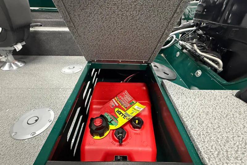 Slide: The Image of Open storage compartment in 2026 Lund Angler 1650 SS boat, revealing red fuel tank. - 8