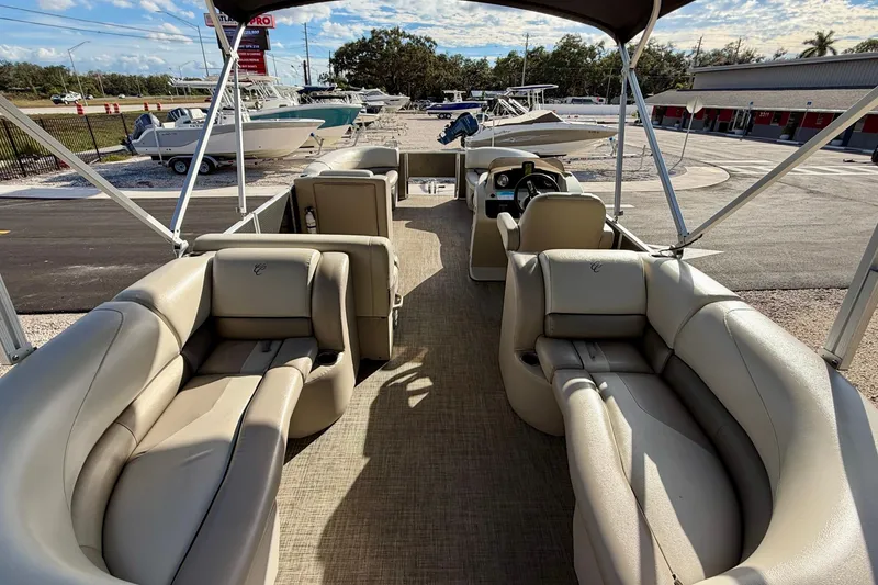 Slide: The Image of Luxurious seating on 2022 Cypress Cay Seabreeze 232 pontoon boat, featuring beige upholstery and cup holders. - 10