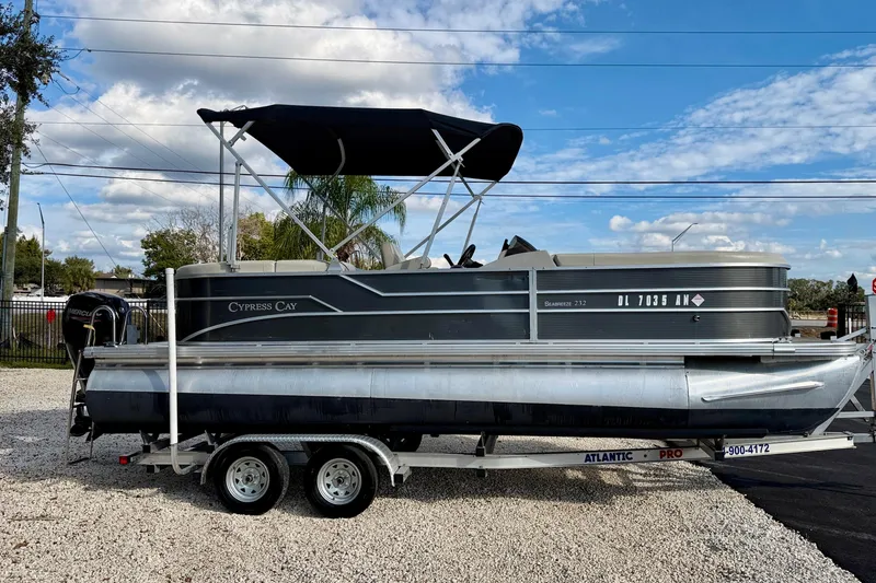 Slide: The Image of 2022 Cypress Cay Seabreeze 232 pontoon boat on trailer, under clear blue sky. - 4