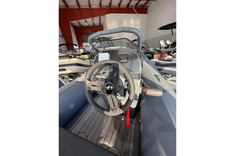 Slide: The Image of 2026 Highfield Sport 390 boat interior with steering wheel and dashboard in a showroom. - 3