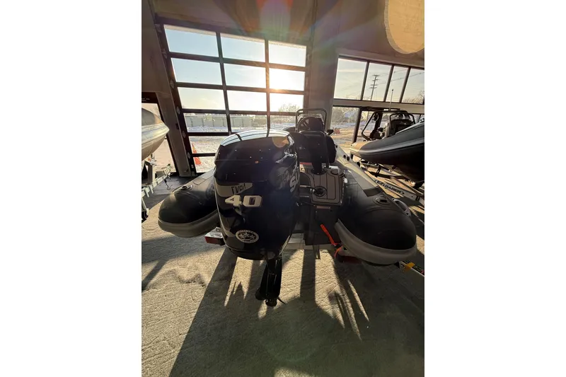 Slide: The Image of 2026 Highfield Sport 360 boat with 40 HP engine in a sunlit showroom. - 10