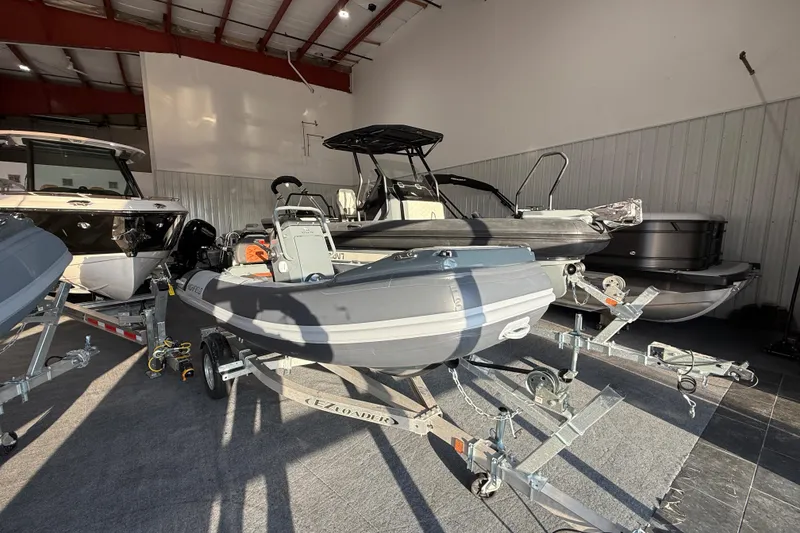 Slide: The Image of 2026 Highfield Sport 360 boat on trailer in showroom, surrounded by other boats. - 8