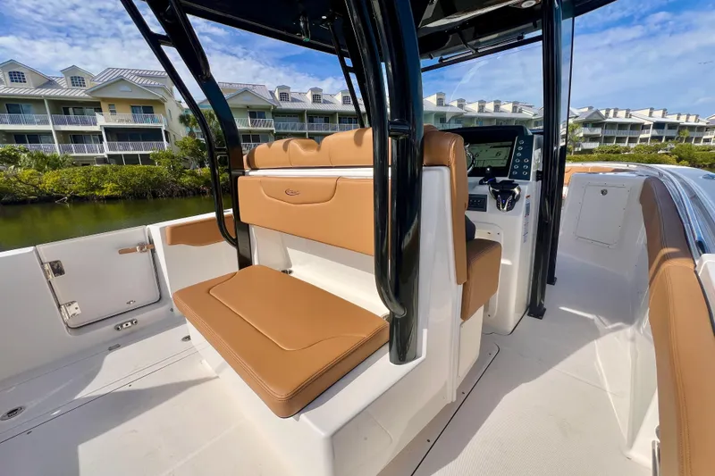 Slide: The Image of 2025 Robalo R302 Center Console boat interior with tan seating and American flag. - 11