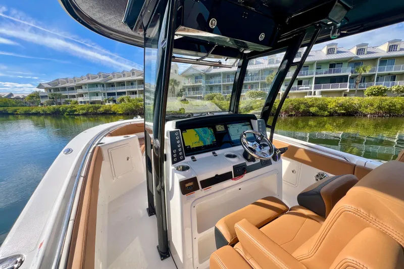 Slide: The Image of 2025 Robalo R302 Center Console boat interior with tan seating and modern dashboard. - 12