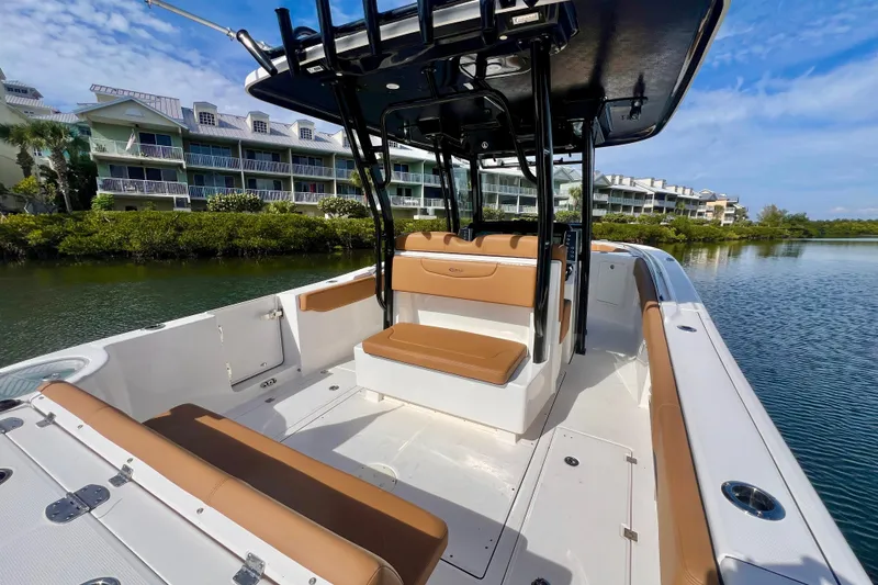 Slide: The Image of 2025 Robalo R302 Center Console boat on water, near waterfront homes and palm trees. - 8
