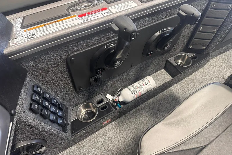 Slide: The Image of 2026 Lund 1875 Pro-V boat interior with controls, cup holders, and fire extinguisher. - 20