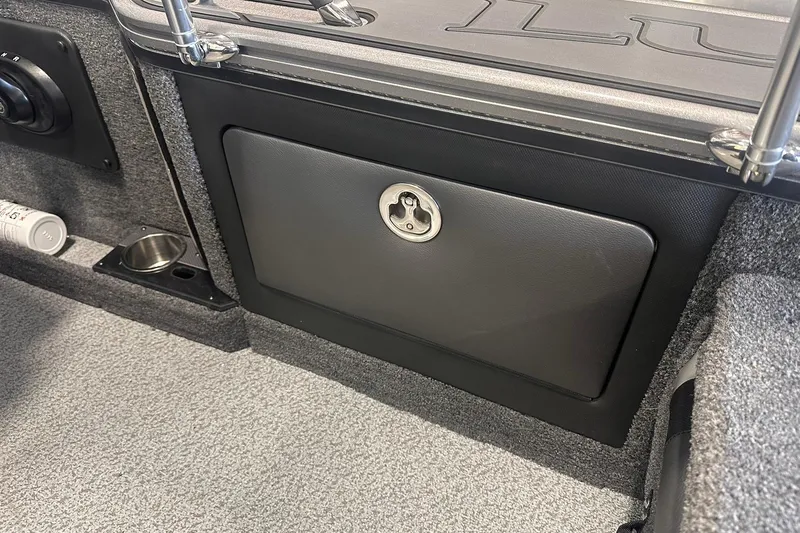 Slide: The Image of Interior of 2026 Lund 1875 Pro-V boat, featuring storage compartment and cup holder. - 28