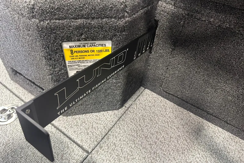 Slide: The Image of 2026 Lund 1875 Pro-V boat interior with capacity label and branding. - 32