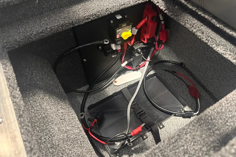 Slide: The Image of 2026 Lund 1875 Pro-V boat battery compartment with wiring and connections. - 34