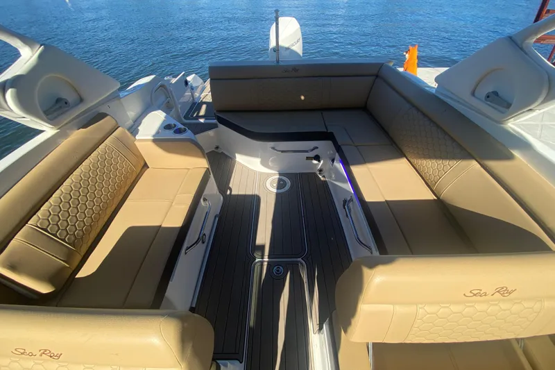 Slide: The Image of 2022 Sea Ray SDX 270 Outboard boat interior with tan seating and water view. - 12
