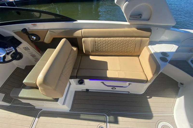 Slide: The Image of 2022 Sea Ray SDX 270 Outboard boat interior with tan seating and cup holders. - 14
