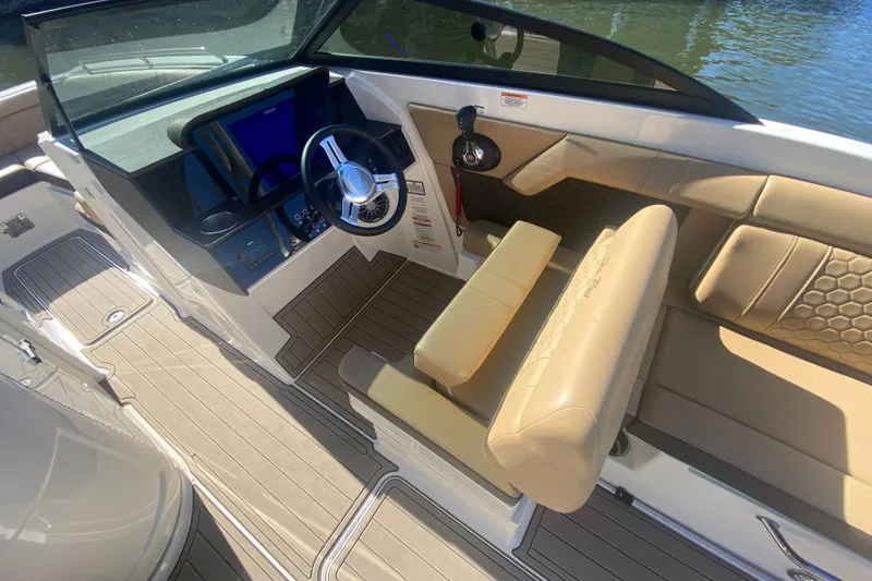 Slide: The Image of 2022 Sea Ray SDX 270 Outboard boat interior with beige seating and modern dashboard. - 15