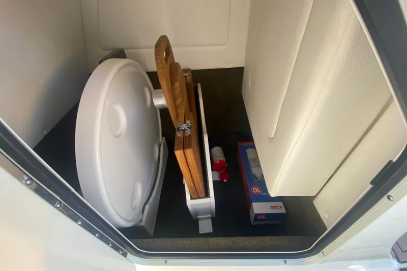 Slide: The Image of 2022 Sea Ray SDX 270 Outboard storage compartment with toilet and cleaning supplies. - 30