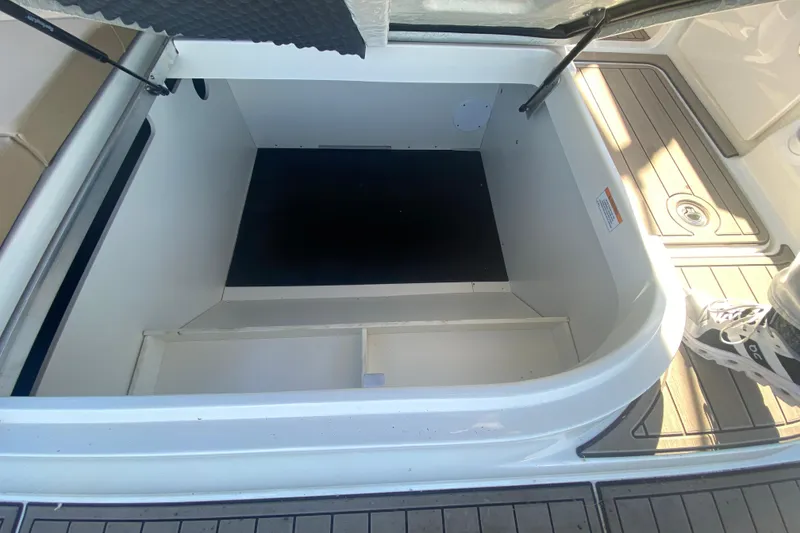 Slide: The Image of 2022 Sea Ray SDX 270 Outboard storage compartment, open and empty, with deck flooring visible. - 33