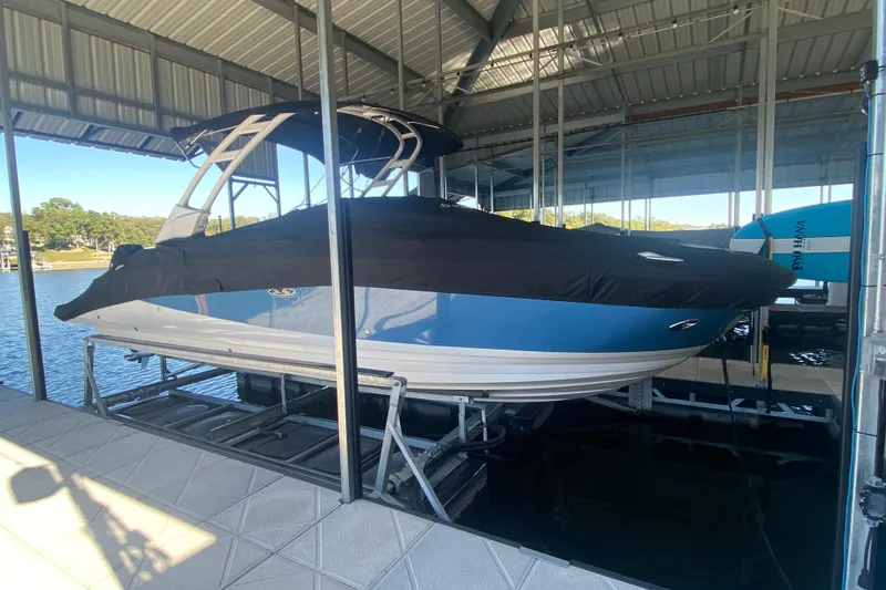 Slide: The Image of 2022 Sea Ray SDX 270 Outboard boat docked under a covered marina. - 37