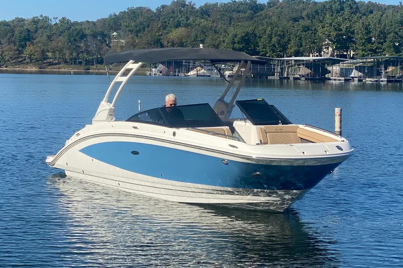 Slide: The Image of 2022 Sea Ray SDX 270 Outboard boat on a calm lake with trees in the background. - 38