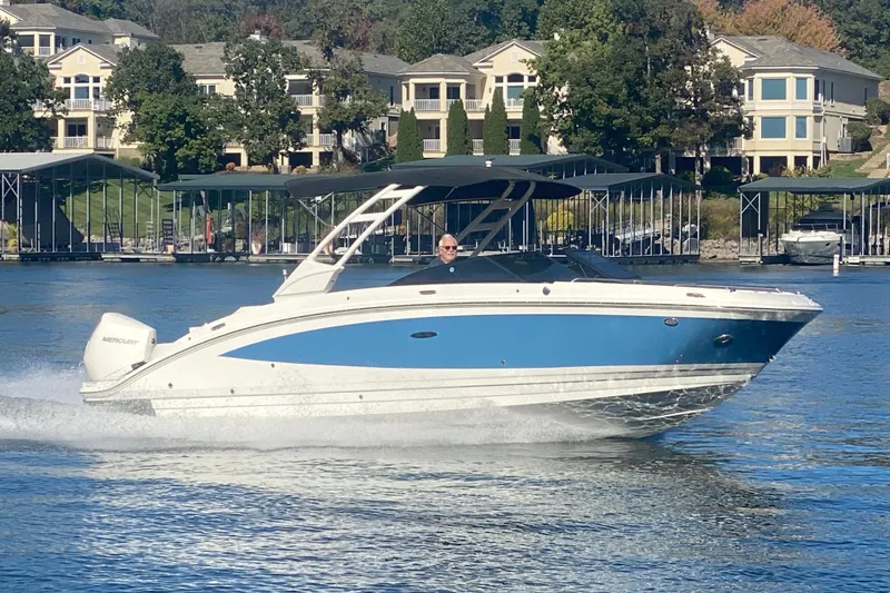 Slide: The Image of 2022 Sea Ray SDX 270 Outboard cruising on a lake near waterfront homes. - 7