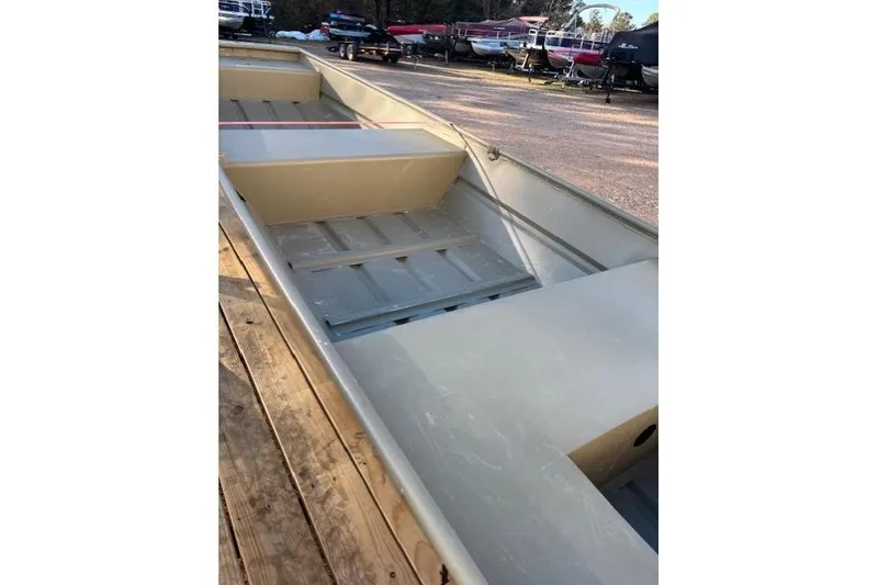 Slide: The Image of 2024 Tracker Grizzly 1436 Jon boat on trailer, displayed outdoors near a building. - 3