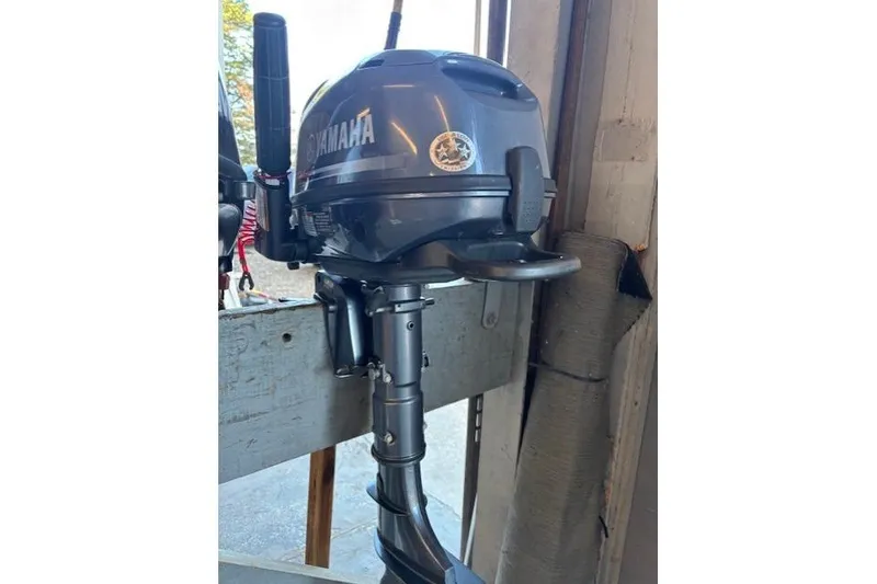 Slide: The Image of 2024 Tracker Grizzly 1436 Jon boat, green, on wooden platform near metal fence. - 5