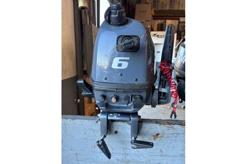 Slide: The Image of 2024 Tracker Grizzly 1436 Jon boat on wooden dock, showcasing interior seating and storage. - 6